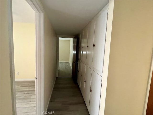 hall with light wood-style floors and baseboards