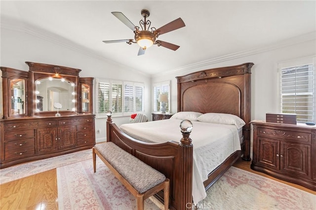 bedroom with ornamental molding, light wood-style flooring, ceiling fan, and lofted ceiling