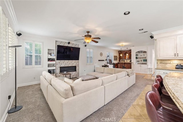 living area featuring light carpet, a brick fireplace, a ceiling fan, visible vents, and ornamental molding