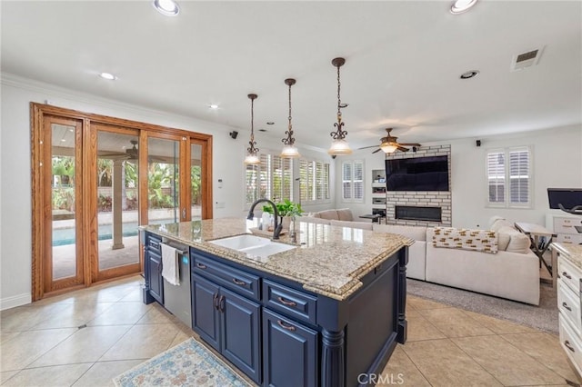 kitchen featuring ceiling fan, blue cabinets, visible vents, a sink, and open floor plan