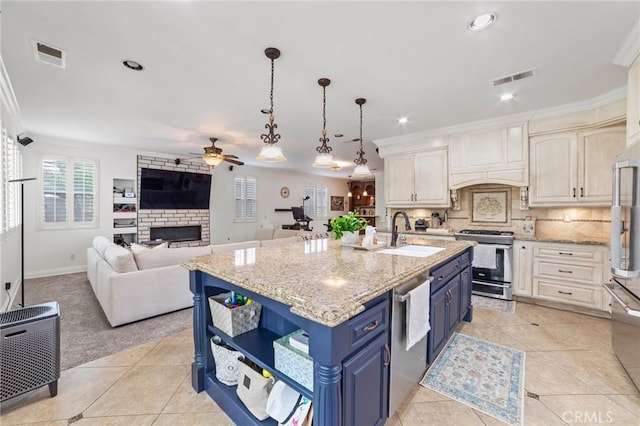 kitchen featuring open shelves, a sink, ceiling fan, blue cabinets, and appliances with stainless steel finishes