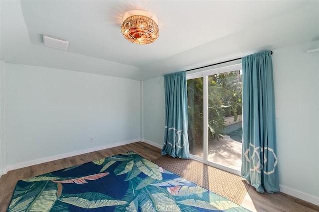 unfurnished room with baseboards and wood finished floors