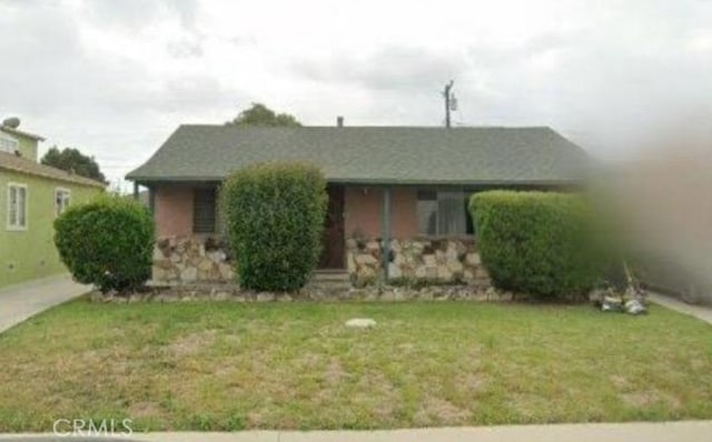 view of front of house featuring stone siding and a front yard