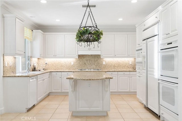 kitchen with white appliances, white cabinets, a sink, and light tile patterned floors