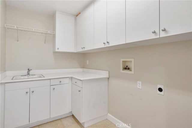 laundry area featuring washer hookup, electric dryer hookup, cabinet space, a sink, and baseboards