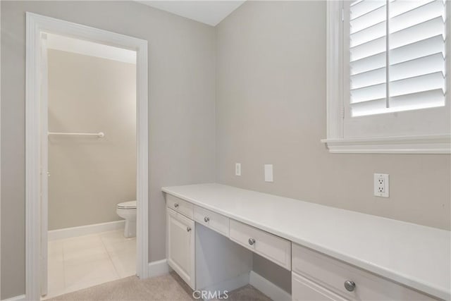 bathroom with baseboards, vanity, and toilet