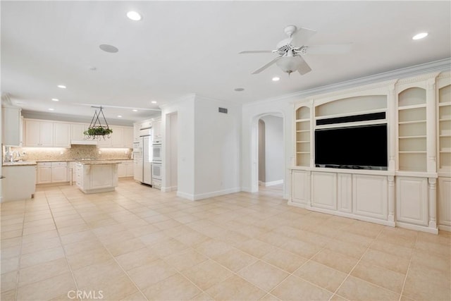 unfurnished living room featuring recessed lighting, crown molding, a sink, and ceiling fan