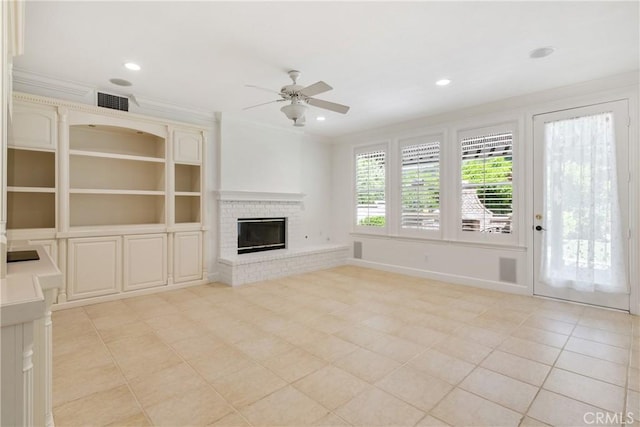 unfurnished living room with ceiling fan, visible vents, a fireplace, light tile patterned floors, and ornamental molding
