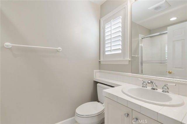 bathroom with vanity, toilet, baseboards, an enclosed shower, and visible vents