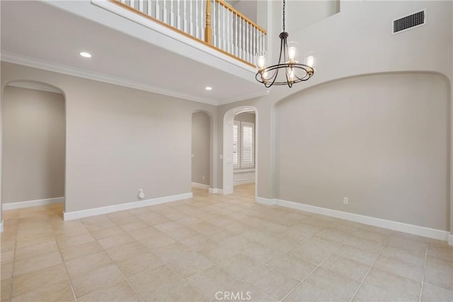 spare room with crown molding, arched walkways, and visible vents