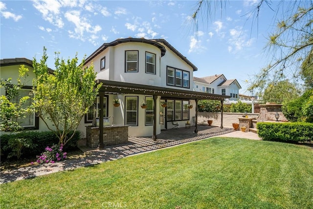 back of property featuring a patio, stucco siding, and a yard