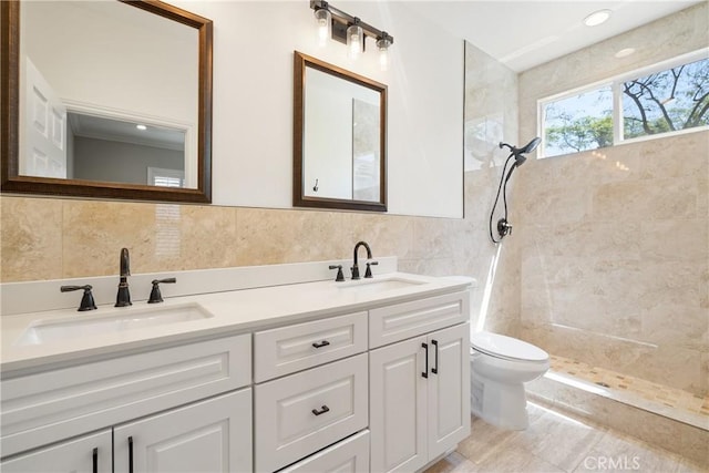 full bathroom featuring a sink, tile walls, a tile shower, and toilet