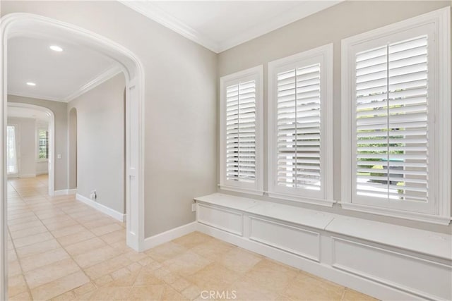 interior space featuring baseboards, arched walkways, recessed lighting, and ornamental molding