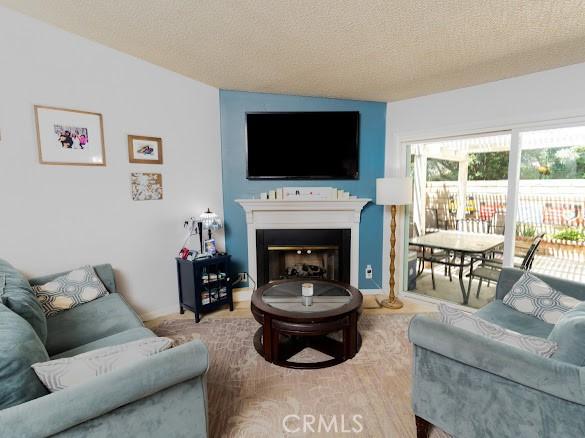 909 Shady Ln, Glendora, CA 91740 - living area with a textured ceiling and a fireplace