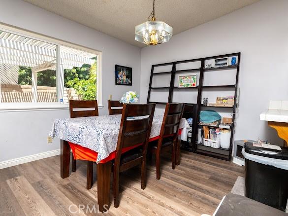 909 Shady Ln, Glendora, CA 91740 - dining room with a chandelier, wood finished floors, baseboards, and a textured ceiling