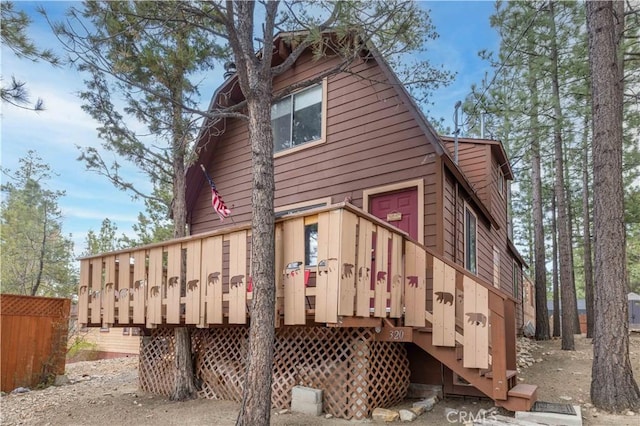 rear view of property featuring stairway and a wooden deck