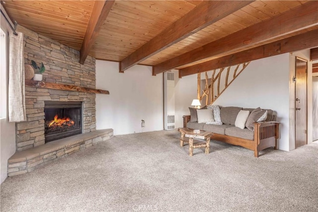 carpeted living area with a stone fireplace, wood ceiling, and beamed ceiling