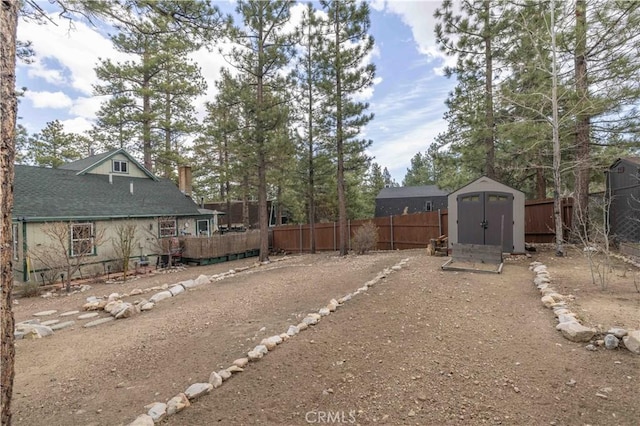 view of yard featuring an outdoor structure, fence private yard, and a storage unit