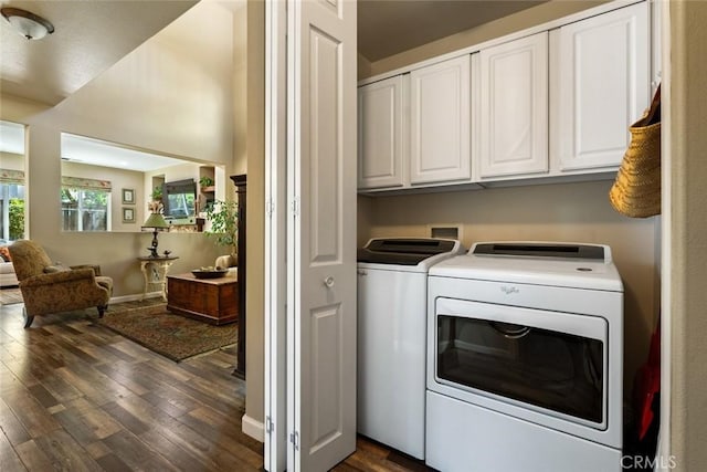 clothes washing area featuring washing machine and clothes dryer, dark wood-style flooring, baseboards, and cabinet space