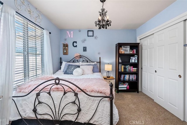 bedroom featuring a closet, carpet flooring, and a notable chandelier
