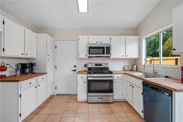 1148 Arlington Ct, Rosamond, CA 93560 - kitchen featuring wooden counters, white cabinetry, tasteful backsplash, a sink, and appliances with stainless steel finishes