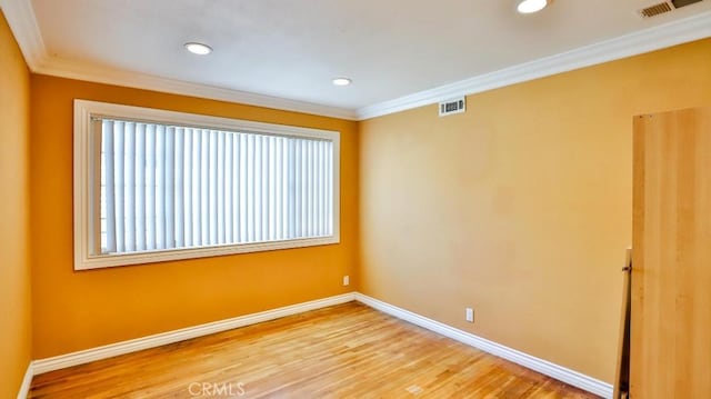 unfurnished room featuring baseboards, ornamental molding, light wood-style flooring, and visible vents