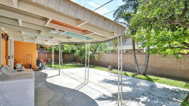 view of patio with washer / clothes dryer and a fenced backyard