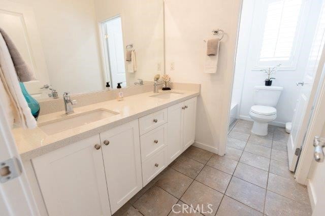 2630 Luminous Ln, Costa Mesa, CA 92626 - full bathroom with toilet, tile patterned floors, double vanity, and baseboards