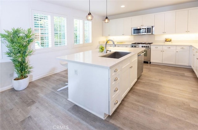 2630 Luminous Ln, Costa Mesa, CA 92626 - kitchen featuring appliances with stainless steel finishes, a sink, light countertops, light wood-type flooring, and white cabinetry