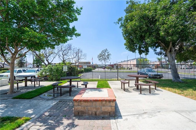 view of property's community with a patio, a fire pit, and fence