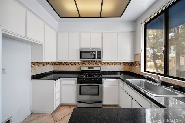 kitchen with a sink, decorative backsplash, appliances with stainless steel finishes, and a healthy amount of sunlight
