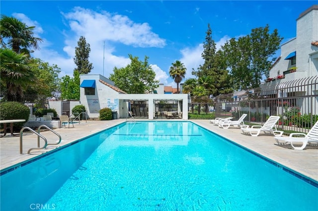 pool with fence and a patio area
