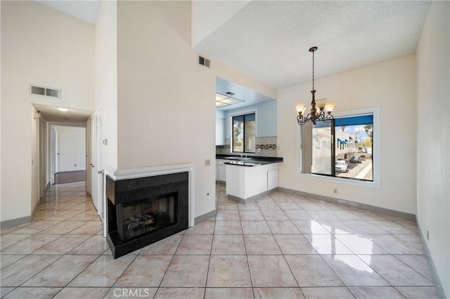 unfurnished dining area with baseboards, a notable chandelier, visible vents, and light tile patterned floors