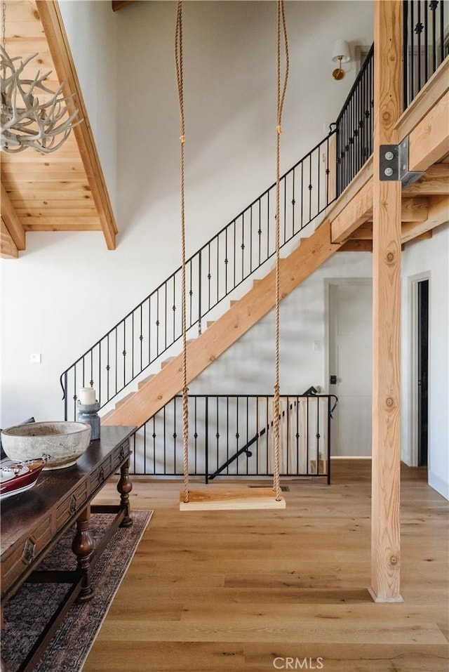 28805 N Shore Rd, Lake Arrowhead, CA 92352 - staircase featuring beam ceiling, wood finished floors, and a towering ceiling