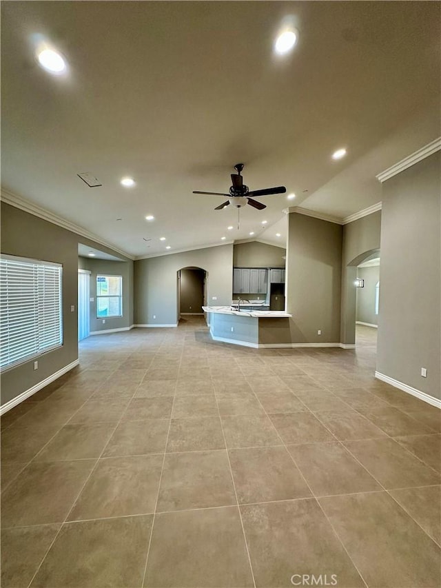unfurnished living room with arched walkways, ornamental molding, and recessed lighting