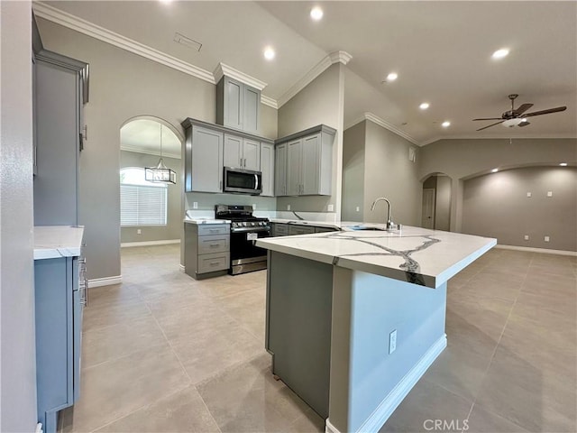 kitchen with crown molding, arched walkways, vaulted ceiling, gray cabinetry, and stainless steel appliances