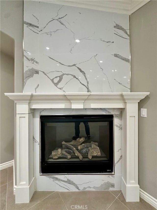 room details featuring a glass covered fireplace and baseboards