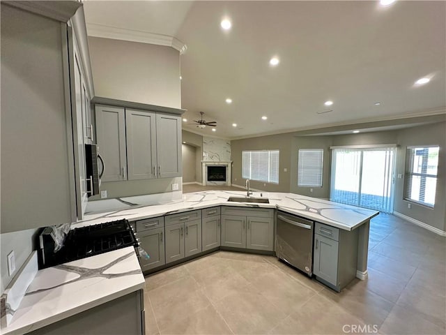 kitchen featuring ceiling fan, appliances with stainless steel finishes, a sink, gray cabinets, and open floor plan