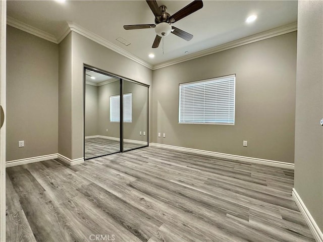 unfurnished bedroom featuring wood finished floors, baseboards, a closet, ornamental molding, and recessed lighting