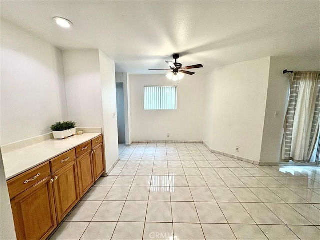 empty room featuring a ceiling fan and light tile patterned flooring