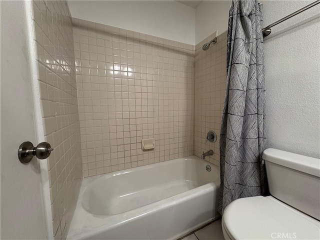 bathroom featuring toilet and shower / tub combo with curtain