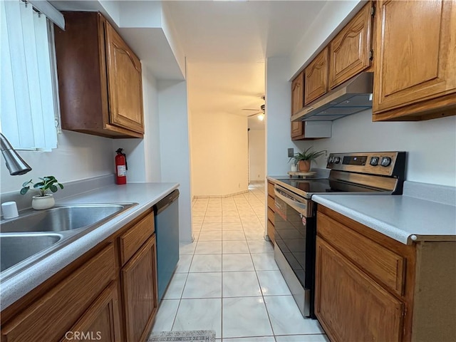 kitchen featuring stainless steel range with electric stovetop, under cabinet range hood, a sink, dishwashing machine, and brown cabinets