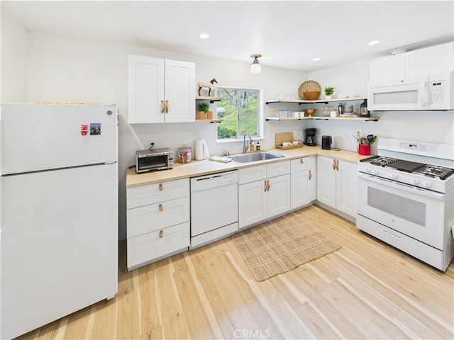kitchen with open shelves, white appliances, light wood-type flooring, white cabinetry, and a sink
