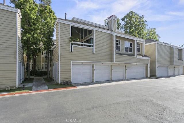 exterior space with a chimney and an attached garage