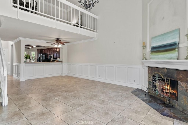 3630 S Bear St Unit 67, Santa Ana, CA 92704 - unfurnished living room featuring a fireplace, ceiling fan, light tile patterned floors, a high ceiling, and a decorative wall