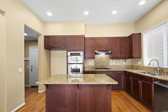 1703 Oconnor Ave, Chula Vista, CA 91913 - kitchen featuring appliances with stainless steel finishes, under cabinet range hood, light wood-style floors, a center island, and backsplash