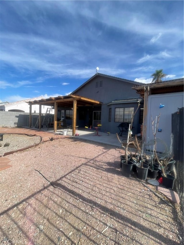 back of property featuring a patio, stucco siding, and fence