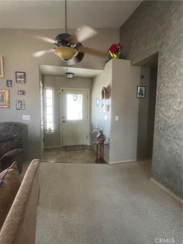 carpeted living area featuring ceiling fan and baseboards