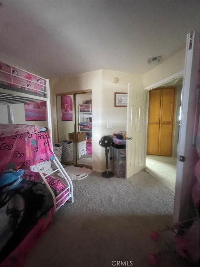 carpeted bedroom featuring visible vents and a closet