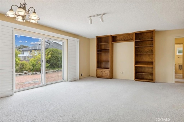 2132 El Dorado St, Los Osos, CA 93402 - unfurnished living room featuring an inviting chandelier, a textured ceiling, and light carpet
